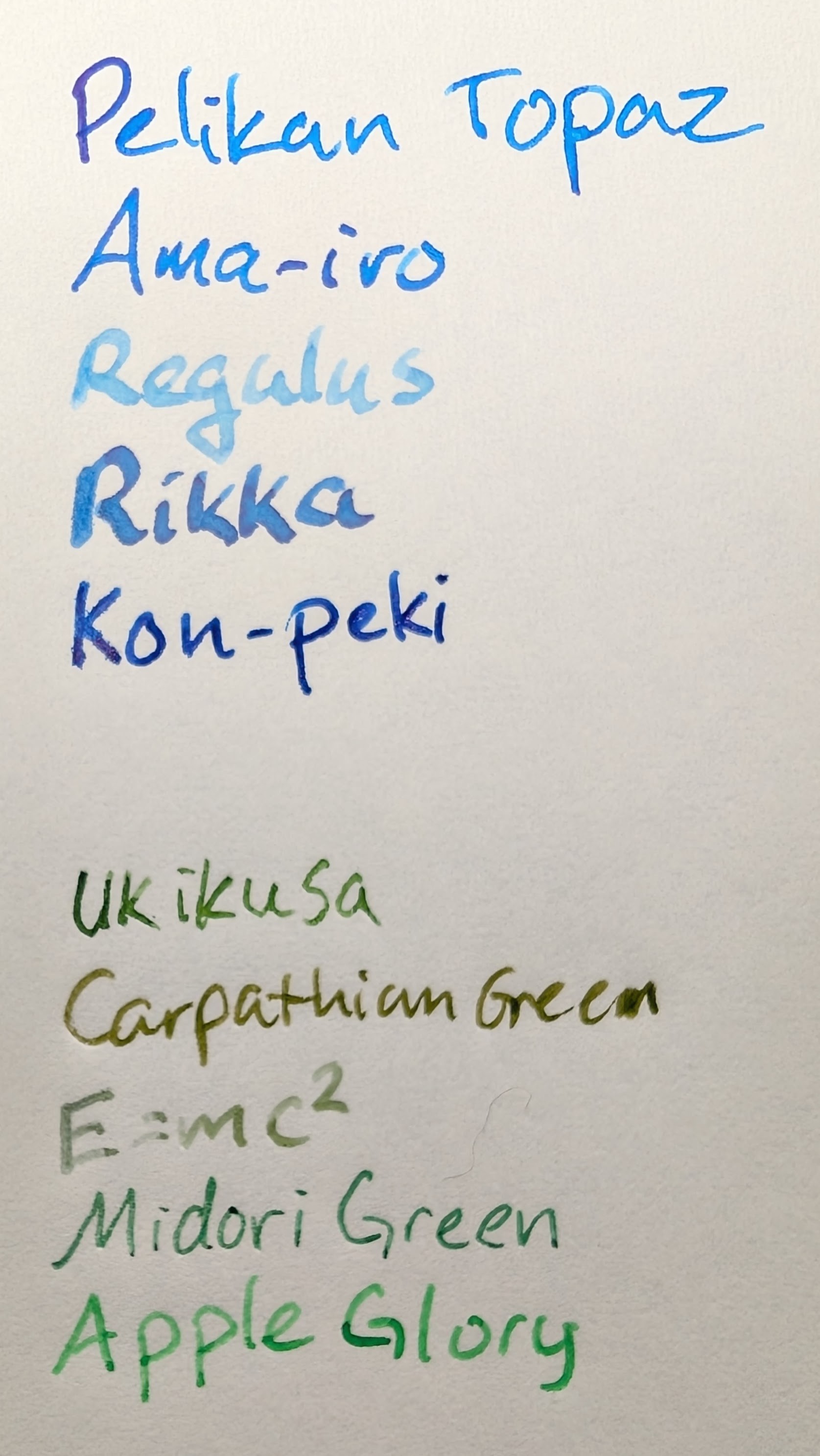 Writing samples in two groups. Top group are all shades of light blue: * "Pelikan Topaz" (Light blue with some red sheen) * "Ama-iro" (Light blue with some red sheen) * "Regulus" (Very light slate blue) * "Rikka" (Medium slate blue with red sheen) * "Kon-peki" (Medium blue) Bottom group are all shades of green: * "Ukikusa" (Light slate green) * "Carpathian Green" (Grassy olive-green) * "E=mc2" (Olive green) * "Midori Green" (Green-leaning teal) * "Apple Glory" (Very bright green)