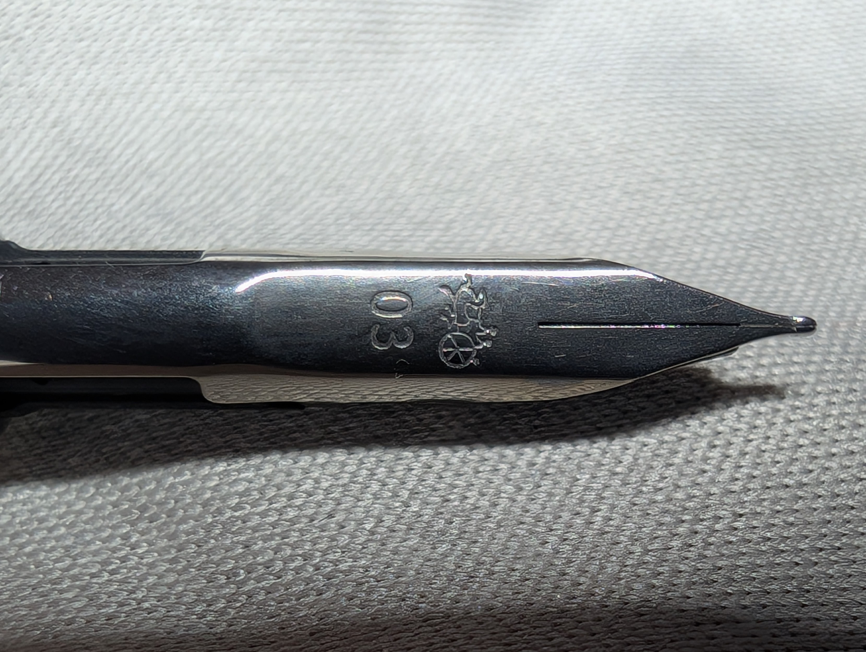 Close-up horizontal photo of a fountain pen nib. It has the Jinhao logo and "03" on it
