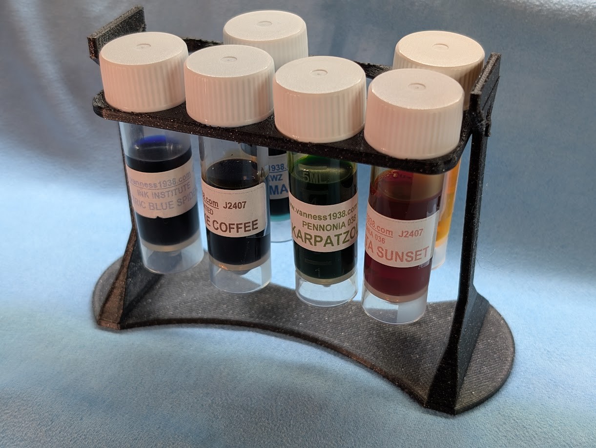 Photo of a 3D printed sample vial rack from the edge. There are sample six vials in the rack and two empty spaces. From this angle the print looks decently clean.