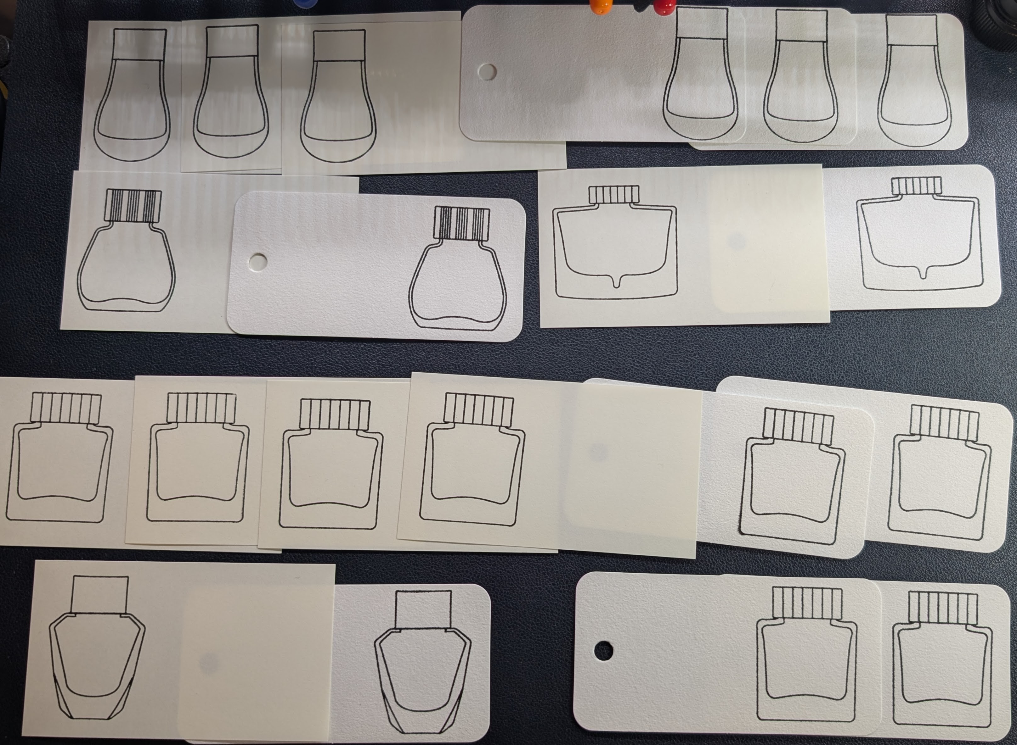Photo of 20 swatch cards arranged on a desk, half are Midori paper, half are col-o-ring. The cards use five different stamp types.