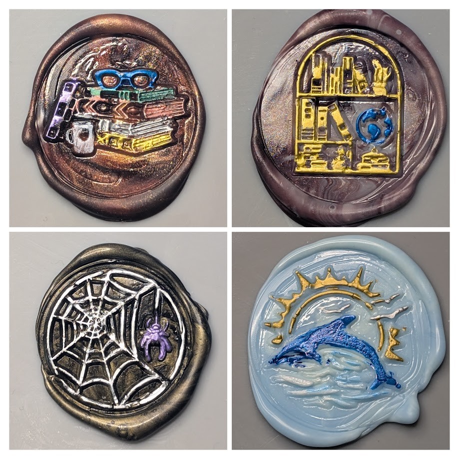 Photo collage of four wax seals made using stamps with various designs. Top left: A stack of books with a coffee mug in front and a pair of glasses on top. Base wax color is brown with some shiny gold mixed in. The books are in various metallic colors, silver, green, copper, gold, and white. Top right: A bookshelf with a rounded/arched top. It is mostly full of books, but also contains a globe and what may be a crystal of some sort. Base wax color is a shiny brownish color with some darker brown swirled in. Bottom left: A spider web and spider. The base wax color is black and orange. The web is colored in white with the spider in purple. Bottom right: A dolphin jumping out of water in front of a sun with seagulls in the background. The base color is several light shades of blue mixed with some white. The dolphin is dark blue, the wave crests are white, the birds are silver, and the sun is gold.