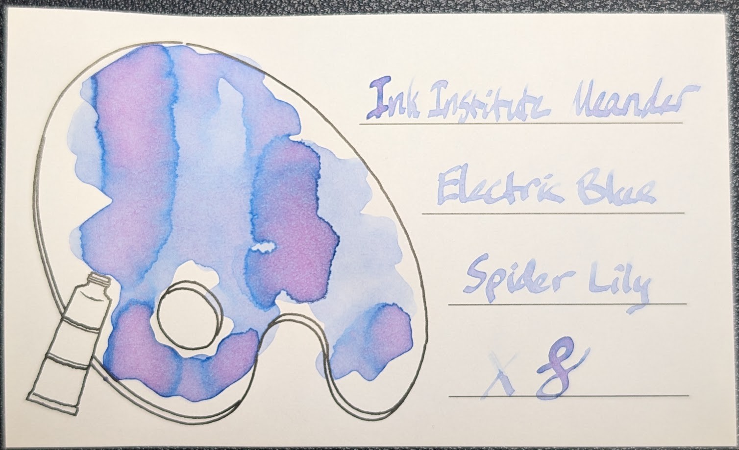 Photo of an Iroful swatch card with a line drawing of a paint palette. The ink on the card is an ink that appears both light blue and pink in different places. On the left, inside the line drawing is a blob of ink which is light blue in places with less ink, and in places with more ink it's pink with dark blue edges. On the right is text reading "Ink Institute Meander Electric Blue Spider Lily" with an X and a curlicue underneath. The text is light, but legible. Some letters are darker and in those letters the edges are darker blue and the center is pink.