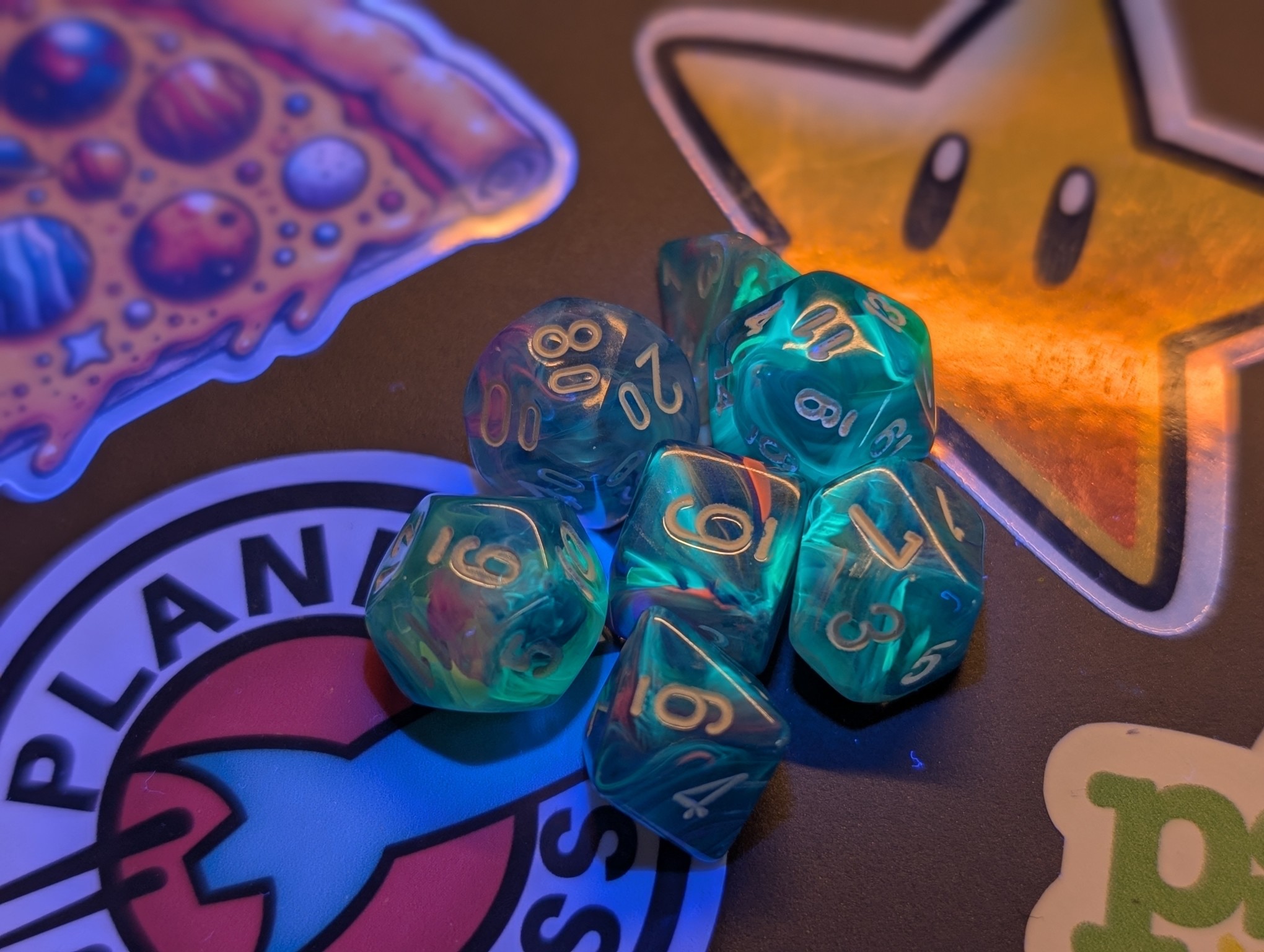 Photo of just the dice under UV together in a clump. The green parts are glowing even brighter.