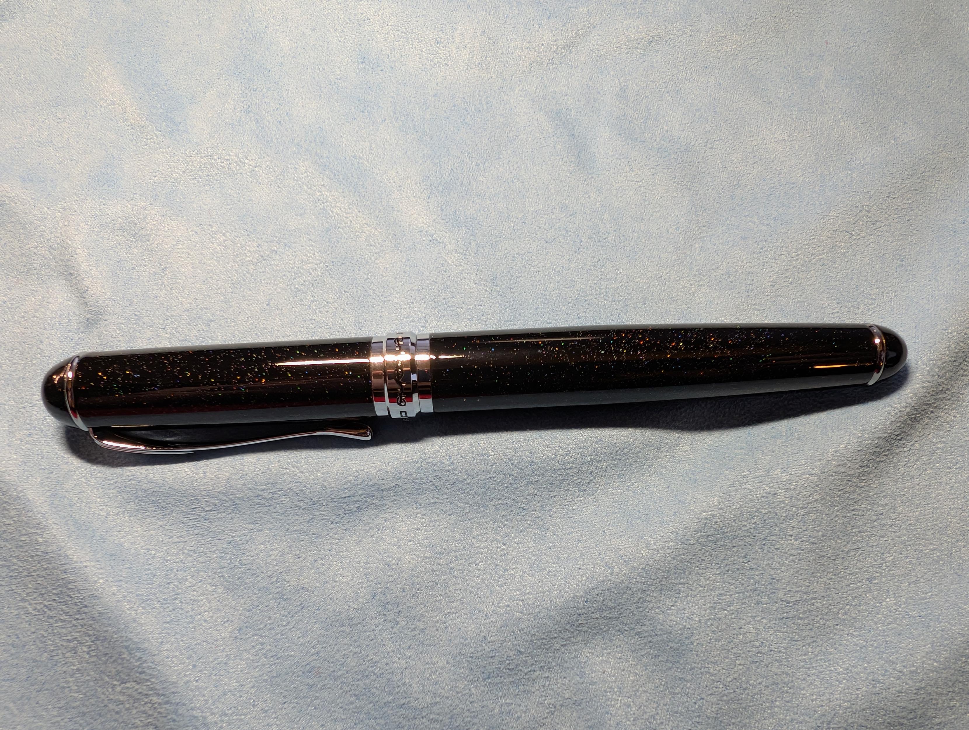 Whole view of the fountain pen. The pen is black with a little sparkle giving it a slight starry night sky look.