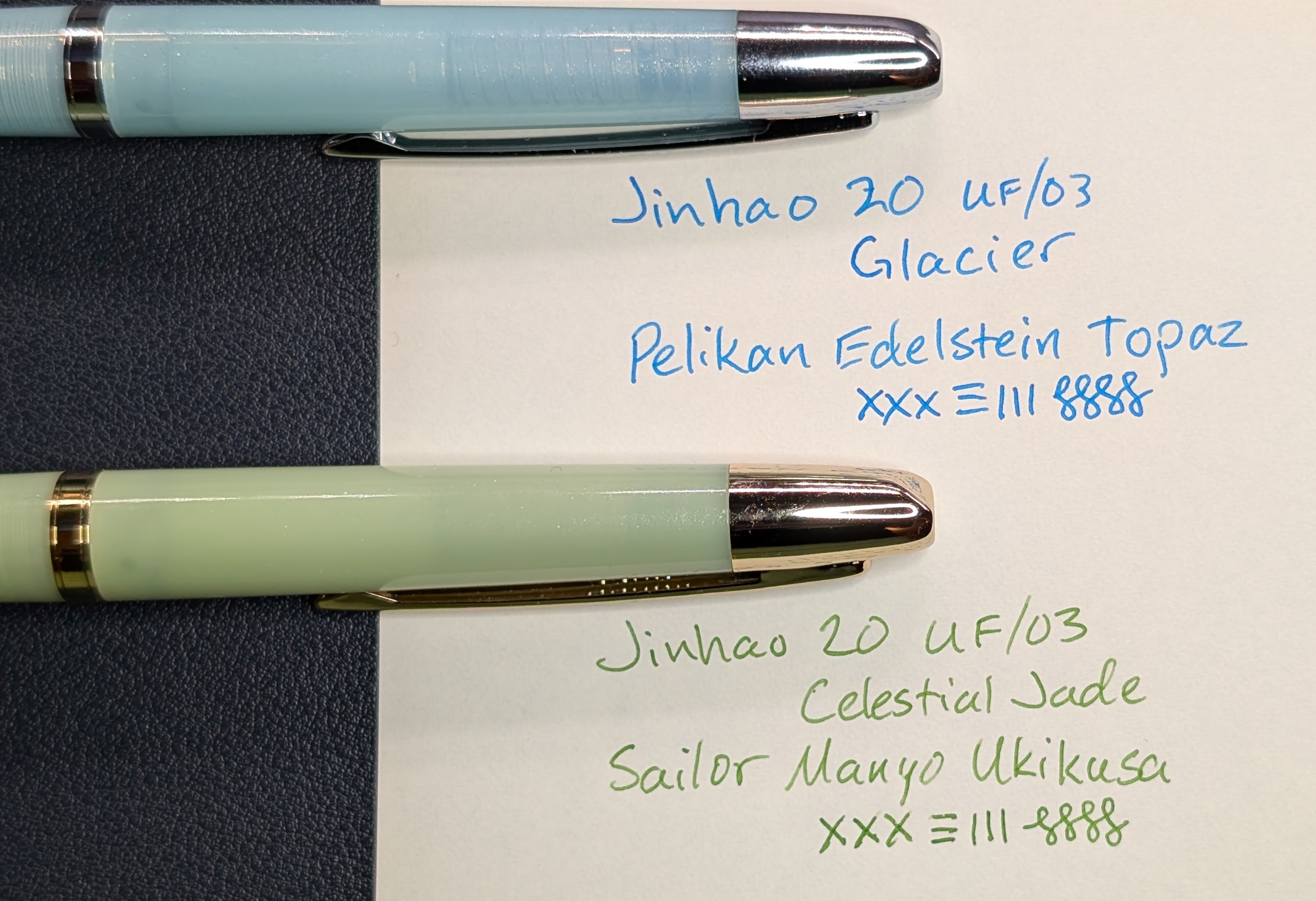 Photo of two fountain pens next to two writing samples on paper. The top pen is transparent light blue with a little visible shimmer to it and has silver trim. The writing sample next to it reads "Jinhao 20 UF/03 / Glacier / Pelikan Edelstein Topaz" followed by a few pen strokes in various directions. The bottom pen is a milky but still transparent light green with a little visible shimmer to it and has gold trim. The writing sample next to it reads "Jinhao 20 UF/03 / Celestial Jade / Sailor Manyo Ukikusa" followed by a few pen strokes in various directions.