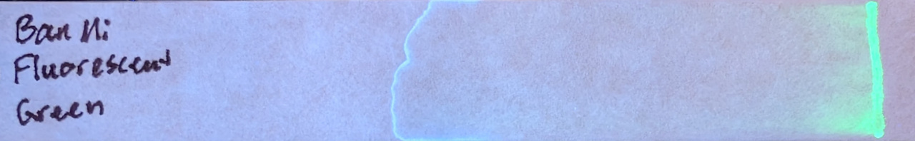 Photo of chromatography paper under UV light.