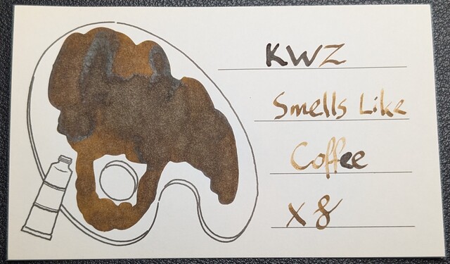 Photo of an Iroful swatch card with a line drawing of a paint pallette. The ink on the card is a dark brown with lots of shading so several areas are a little lighter brown. On the left, inside the line drawing is a blob of ink with swirls and spots of darker ink. On the right is text reading "KWZ Smells Like Coffee" with an X and a curlicue underneath.