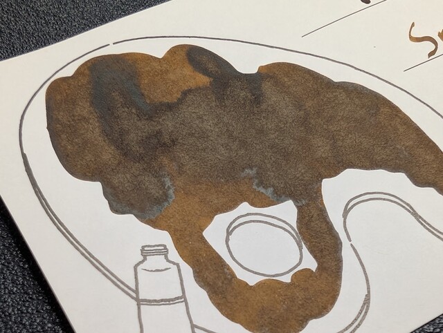 Photo of an Iroful swatch card with a line drawing of a paint pallette taken from an angle. It is the same as before, but because of the angle some areas appear to have some reflective sheen to them.