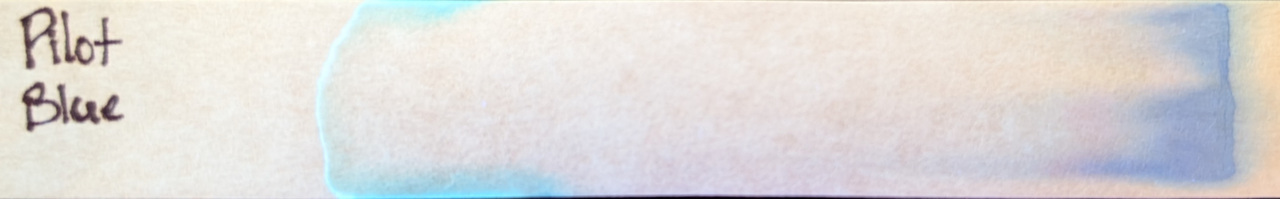 Photo of chromatography paper under UV light.